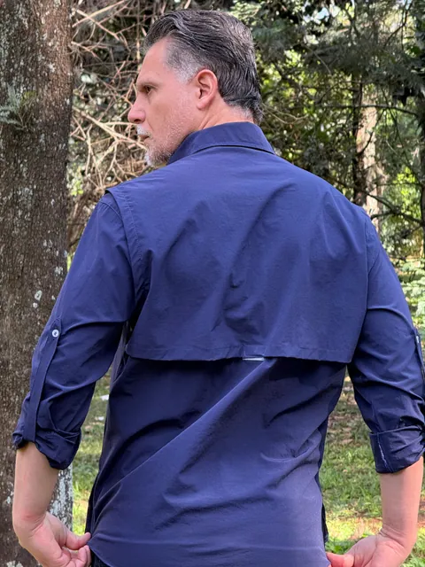 Costas da Camisa de Campo azul marinho em ambiente externo, com a pala de ventilação.