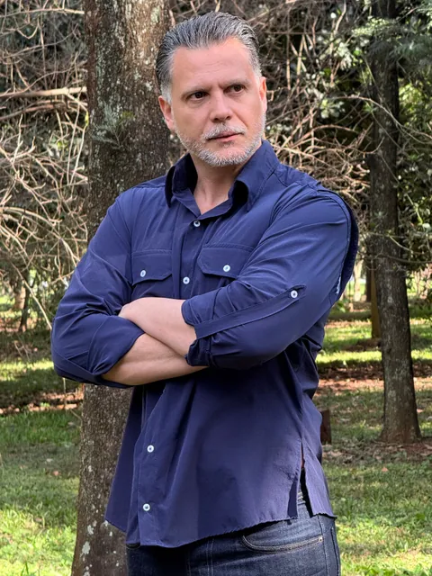 Profissional em ambiente externo vestindo a Camisa de Campo azul marinho.