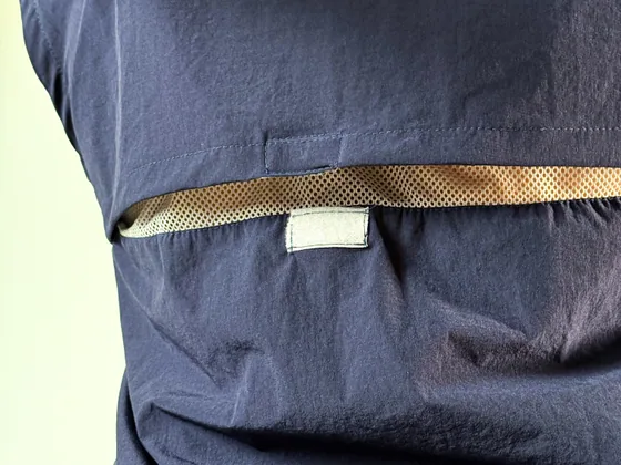 Costas da camisa azul marinho, com a faixa de ventilação em tela sob a pala.